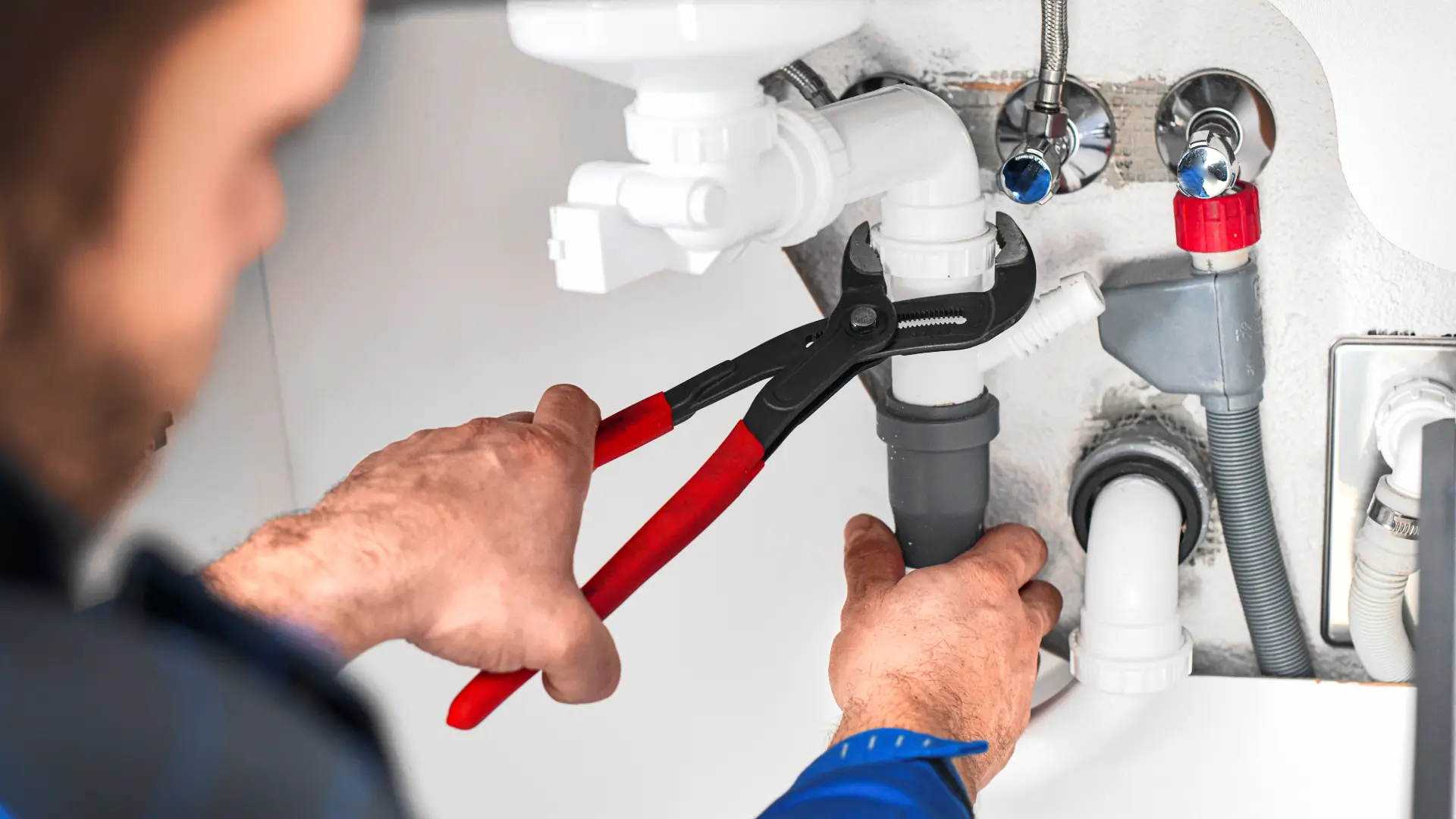 A plumber fixing a broken pipe